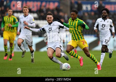 Der Kyle Edwards von West Bromwich Albion wird von Matt Grimes von Swansea City beim Sky Bet Championship Match zwischen Swansea City und West Bromwich Albion im Liberty Stadium, Swansea, in Angriff genommen. Stockfoto