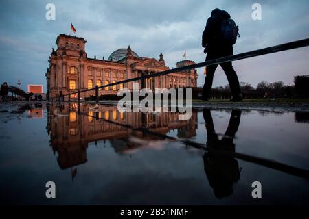 Berlin, Deutschland. März 2020. Das Gebäude des Reichstags glänzt im Abendlicht, die Kulisse spiegelt sich in einer Pfütze wider. Credit: Christoph Soeder / dpa / Alamy Live News Stockfoto