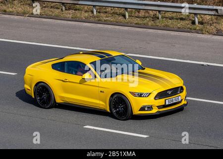 2018 Yellow Ford Mustang GT Auto; UK Vehicular Traffic, Transport, moderne Fahrzeuge, Salonwagen, Fahrzeuge, Fahrzeug, Straßen, Motoren, fahrend in südlicher Richtung auf der Autobahn M6 Stockfoto