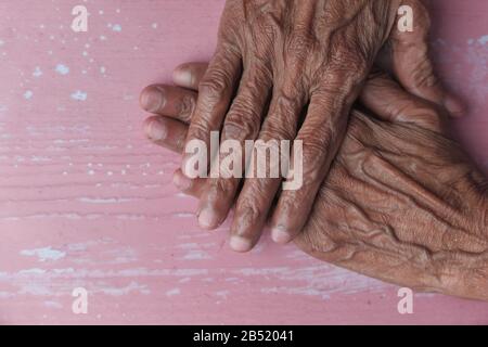 Nahaufnahme der Hände der älteren Frau auf einem Tisch Stockfoto