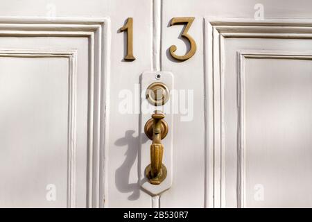 Elegante weiße Holzfront mit der Hausnummer 13 Stockfoto
