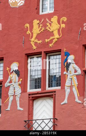 Ritter- und Löwenschmuck an der roten Fassade des Rathauses in Bad Muensteifel Stockfoto