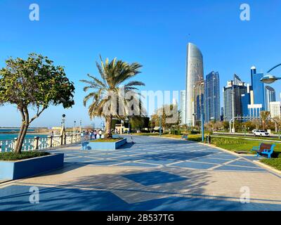 Abu Dhabi/VAE - 6. März 2020: Berühmter Corniche Walk mit vielen Menschen. Schöne lange Corniche Straße mit Wolkenkratzern und Strand in Abu Dhabi Stockfoto