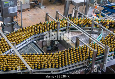 Brisbane, Australien - 8. Dezember 2009: Castlemaine Perkins Brauerei. Der Flaschenstrom auf Transportbändern wird um die Leitstation gespalten. Stockfoto