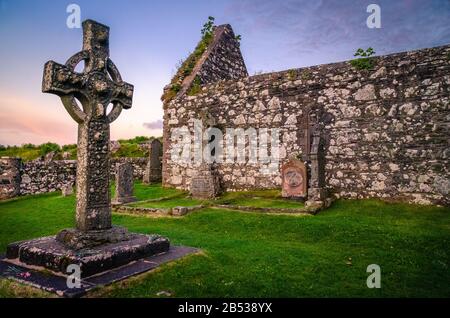 Der Sonnenuntergang auf der Kildalton Chapel, der Insel Islay, Schottland, der UK Kildalton Chapel ist eine zerstörte Kapelle wenige Kilometer östlich von wichtigen Brennereien wie Ardbeg und Stockfoto