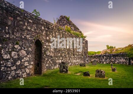 Der Sonnenuntergang auf der Kildalton Chapel, der Insel Islay, Schottland, der UK Kildalton Chapel ist eine zerstörte Kapelle wenige Kilometer östlich von wichtigen Brennereien wie Ardbeg und Stockfoto