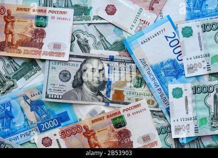 US-Dollar-Banknote auf der russischen Landeswährung, Draufsicht auf gemischte Rubel-Banknoten. KZ-Papiergeld. Rubel und US-Dollar Wechselkurs. Stockfoto