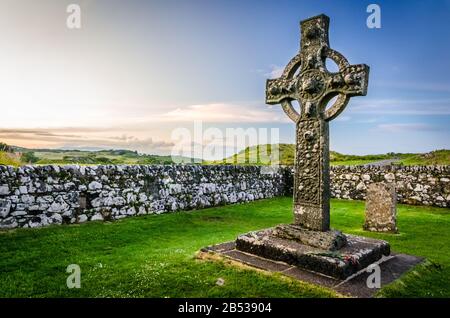 Der Sonnenuntergang auf der Kildalton Chapel, der Insel Islay, Schottland, der UK Kildalton Chapel ist eine zerstörte Kapelle wenige Kilometer östlich von wichtigen Brennereien wie Ardbeg und Stockfoto