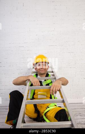 Ein professioneller Maler kompakt und jederzeit einsatzbereit. Er trägt typische Schutzkleidung, die auf der Baustelle verwendet wird. Stockfoto