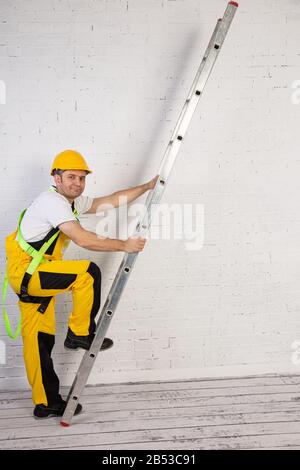 Ein professioneller Maler kompakt und jederzeit einsatzbereit. Er trägt typische Schutzkleidung, die auf der Baustelle verwendet wird. Stockfoto