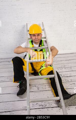 Ein professioneller Maler kompakt und jederzeit einsatzbereit. Er trägt typische Schutzkleidung, die auf der Baustelle verwendet wird. Stockfoto