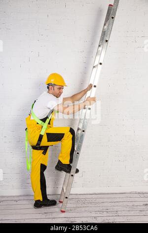 Ein professioneller Maler kompakt und jederzeit einsatzbereit. Er trägt typische Schutzkleidung, die auf der Baustelle verwendet wird. Stockfoto