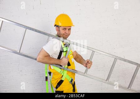 Ein professioneller Maler kompakt und jederzeit einsatzbereit. Er trägt typische Schutzkleidung, die auf der Baustelle verwendet wird. Stockfoto