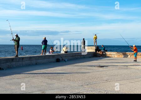 Mehrere kubanische Fischer in der Nähe der Malecon-Promenade am späten Nachmittag. Havanna, Kuba. Stockfoto