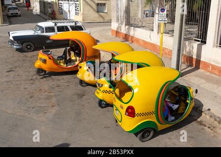 Mehrere Kokotaxi in Havanna, Kuba. Moto Taxi gelbes Fahrzeug rund um die Innenstadt von La Habana sichtbar. Beliebte Transportmöglichkeit für Touristen. Stockfoto