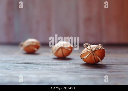 Osterbeige Eier schmücken mit Seil auf braunem Holzhintergrund mit Copyspace Stockfoto