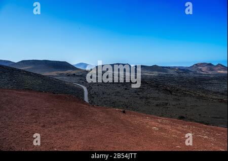 Ausgedehntes Lavafelder, das eine markante Mondlandschaft im Timanfaya Nationalpark, Lanzarote, bietet Stockfoto