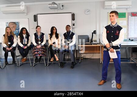 Die Duchess of Sussex (vierte Linke) nimmt während eines Überraschungsbesuchs zur Feier des Internationalen Frauentags an einer Diskussion der 'Senior Debattiergruppe' in der Robert Clack Upper School in Dagenham, Essex Teil. Stockfoto