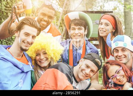 Fröhliche Sportfans, die vor dem Fußballspiel Spaß haben - Anhänger Junger Freunde im Pub beim Fußballspielen im Freien - Freundschaft, Fußball und Siegerkontra Stockfoto