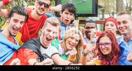 Fröhliche Sportfans haben Spaß beim Fußball-Weltspiel - Junge Anhänger im Pub beim Fußballspielen im Freien - Freundschafts- und Jugendkonzept - Main f. Stockfoto