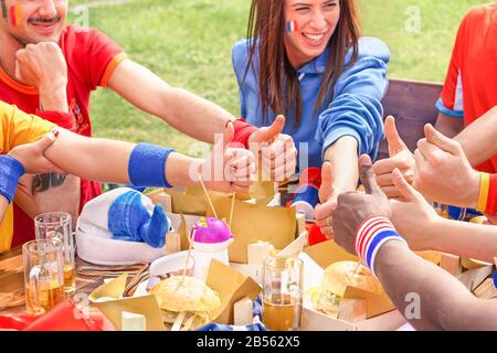 Fußballfans aus verschiedenen Ländern feiern französischen Europacup - Junge glückliche Leute mit Daumen nach oben, um Biergläser zu toben und Burge zu essen Stockfoto