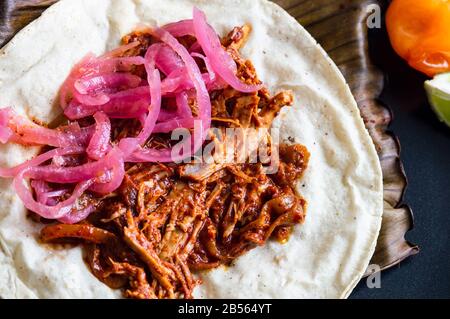 Mexikanischer Tacos von Cochinita Pibil, gebratenes mariniertes Schweinefleisch, serviert mit Habanero-Sauce im Yucatan-Stil und pink eingelegten Zwiebeln Stockfoto