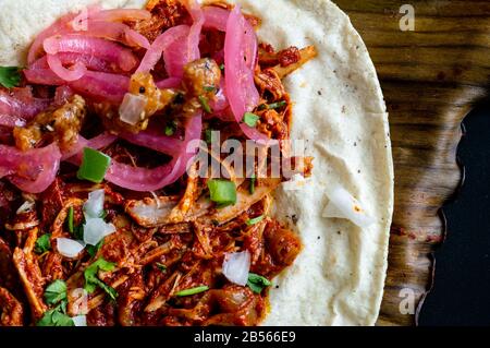 Mexikanischer Tacos von Cochinita Pibil, gebratenes mariniertes Schweinefleisch, serviert mit Habanero-Sauce im Yucatan-Stil und pink eingelegten Zwiebeln Stockfoto