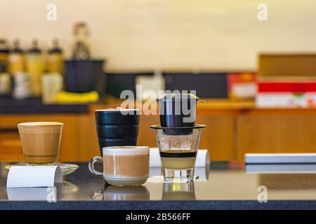 Kondensierter Milchkaffee, der mit Tropffilter in vietnamesischem Kaffeeshop gebrüht wird Stockfoto