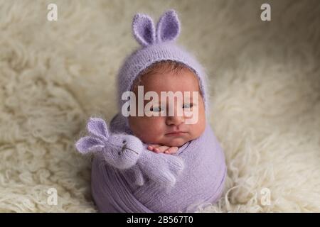 Neugeborenes Mädchen. Fotosession eines Neugeborenen. Neugeborenes Baby in einem Bunny-Hut Stockfoto