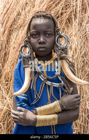 Eine Traditionelle äthiopische Mursi Tribe (ethnische Gruppe) Junge Frau in Traditioneller Kleidung und Kopfkleid im Omo-Tal in einer Sehr abgelegenen Region von Centr Stockfoto