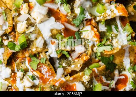 Green Chilaquiles, traditionelles mexikanisches vegetarisches Frühstück aus gebratenen Tortillas und mit grüner Sauce Stockfoto