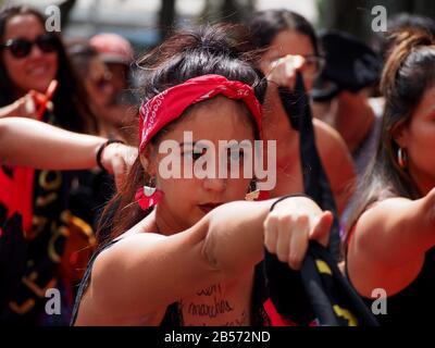 Frauen, die roten Rock und schwarzen Schal tragen, von der Aktivistengruppe "Wir sind 2074", die eine Choreographie durchführt, wenn Tausende feministischer und sympathischer Gruppen in Lima, Peru, auf die Straße gehen und um ihre Rechte am internationalen Frauentag bitten Stockfoto