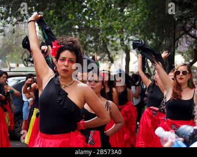 Frauen, die roten Rock und schwarzen Schal tragen, von der Aktivistengruppe "Wir sind 2074", die eine Choreographie durchführt, wenn Tausende feministischer und sympathischer Gruppen in Lima, Peru, auf die Straße gehen und um ihre Rechte am internationalen Frauentag bitten Stockfoto