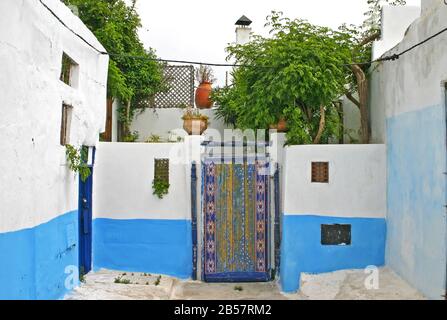 Ornamental bemalte Tür und Innenhof im Wohnteil der alten Kasbah der Udayas in Rabat, der Hauptstadt von Marokko. Stockfoto