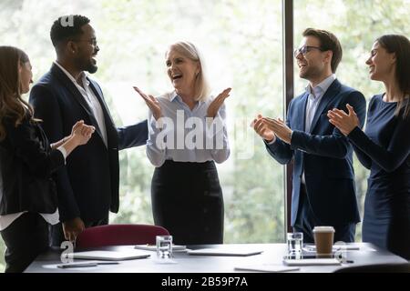 Überglücklich feiern verschiedene Mitarbeiter gemeinsam den Geschäftserfolg des Teams Stockfoto