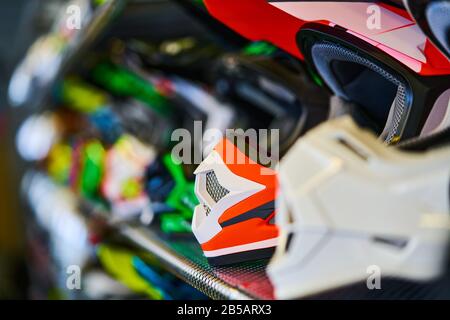 Motorräder und Zubehör im modernen Motorradgeschäft. Biker-Zeug. Helme auf Holzhintergrund. Selektiver Fokus. Stockfoto