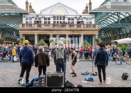 Busker unterhalten eine Menschenmenge im Covent Garden, London, England Stockfoto