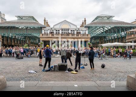 Busker unterhalten eine Menschenmenge im Covent Garden, London, England Stockfoto