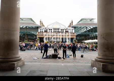 Busker unterhalten eine Menschenmenge im Covent Garden, London, England Stockfoto