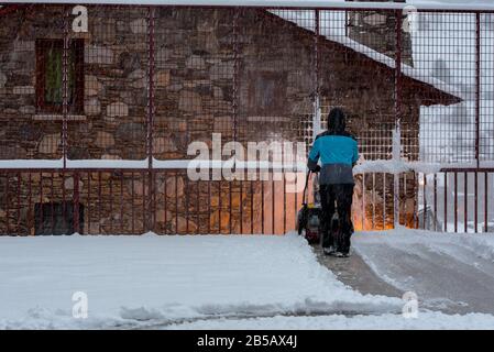 Der Mensch entfernt an einem Wintertag in Andorra Schnee mit der Maschine. Stockfoto