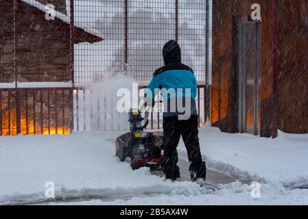 Der Mensch entfernt an einem Wintertag in Andorra Schnee mit der Maschine. Stockfoto