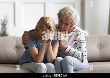 Fürsorgliche ältere Mutter Trost aufrütteln Tochter Stockfoto