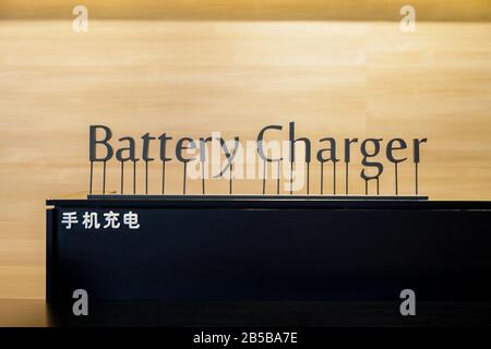 Batterieladegerät - Popup-Schild mit Kunstbrief auf dem schwarzen Zähler mit chinesischer Sprache. Chinesische Laguage im Bild bedeutet Batterieladegerät. Stockfoto