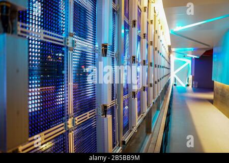 LED-Musteranlage an der Spiegelglaswand von innen nach außen mit Rolltreppe. Stockfoto