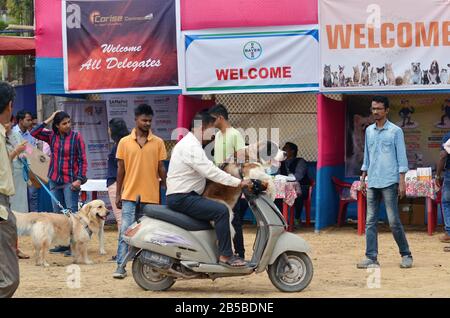 Nagaon, Assam/Indien - 08. März 2020: EIN Hundebesitzer mit seinem Tier kommt auf einem Roller an, um an der zweiten Nagaon Dog Show 2020 teilzunehmen, die von Royal Pe veranstaltet wird Stockfoto