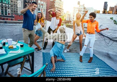 Eine Gruppe von Freunden verbringen gemeinsam Zeit auf einem Dach in der Stadt New york, Lifestyle-Konzept mit glücklichen Menschen Stockfoto
