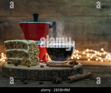 Eine Tasse heißen Kaffee mit Kuchen und italienischer Kaffeekanne (Moka) auf Holztisch. Stockfoto