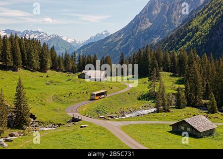 Grosse Scheidegg, Oberhasli, Bern, Schweiz - 19. Juli 2019: Postauto der Schweiz nach Meiringen und vorbei an Alpwiesen von Alpiglen in Upper Stockfoto