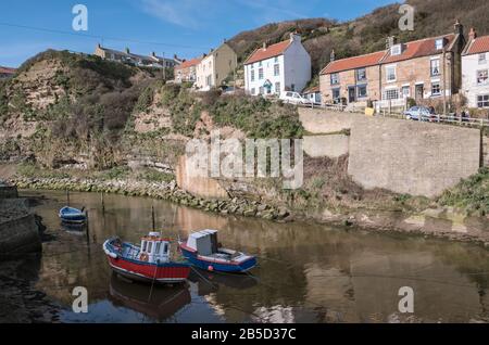 Traditioneller Fischerhafen mit Segelbooten bei Flut, Staithes, North Yorkshire Coast, England, Großbritannien Stockfoto