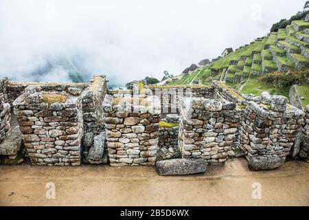 Panoramaaussicht auf Touristen auf ehemaligen landwirtschaftlichen Terrassen der Ruinen von Machu Picchu, Peru. Südamerika. Stockfoto